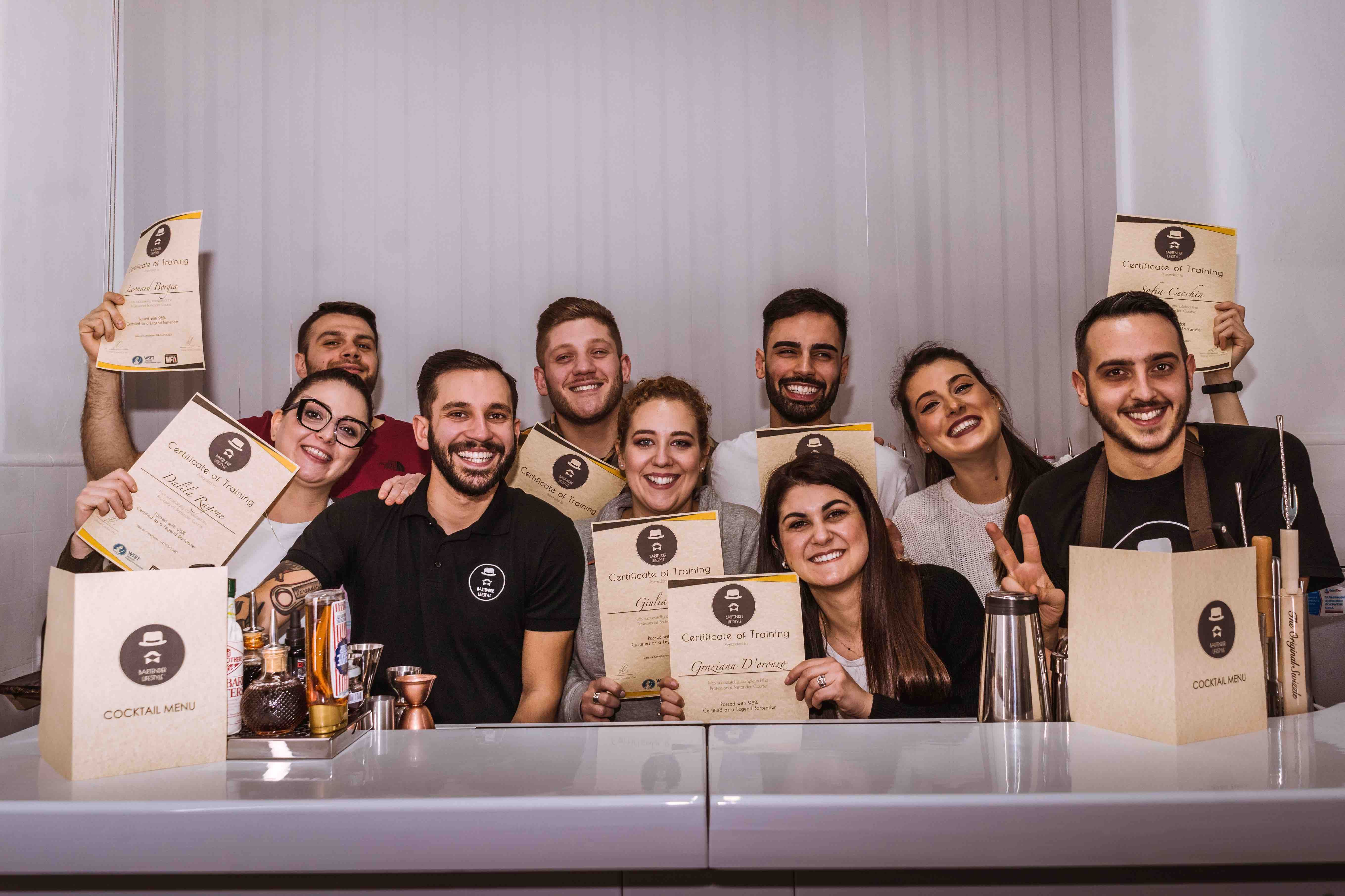 group of classroom students celebrating the end of professional bartender course with certificates